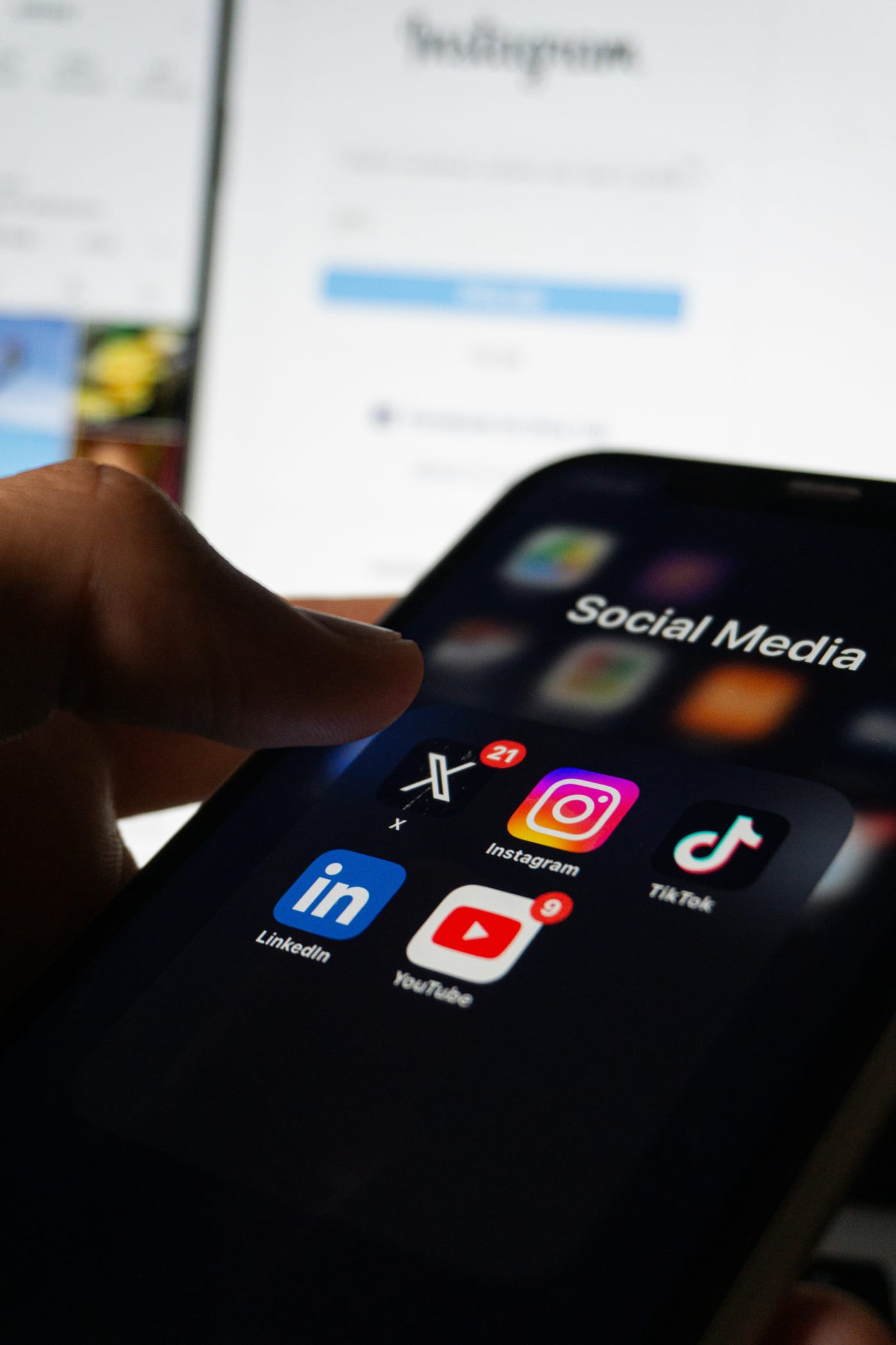 Hand holding a phone with social media apps open